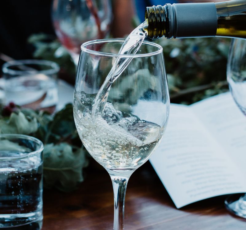 australian viognier from subrosa being poured into a glass at a table