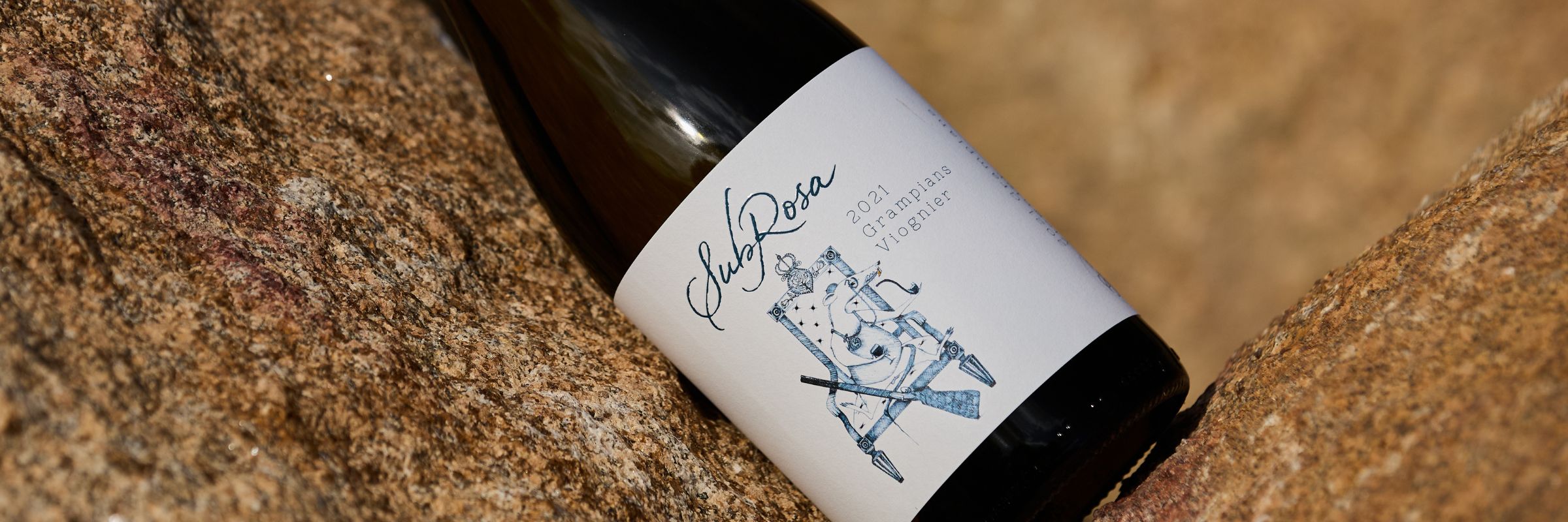 bottle of subrosa viognier lying on the granite rocks in the grampians wine region