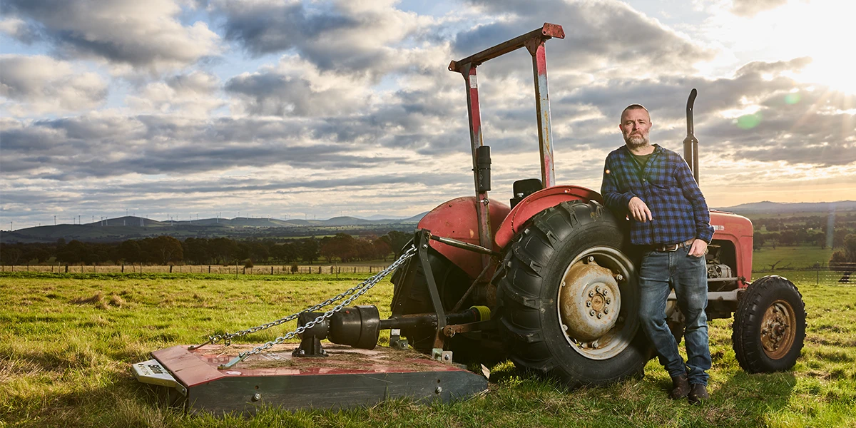 adam louder, subrosa winemaker, standing next to the tractor on the subrosa wine farm