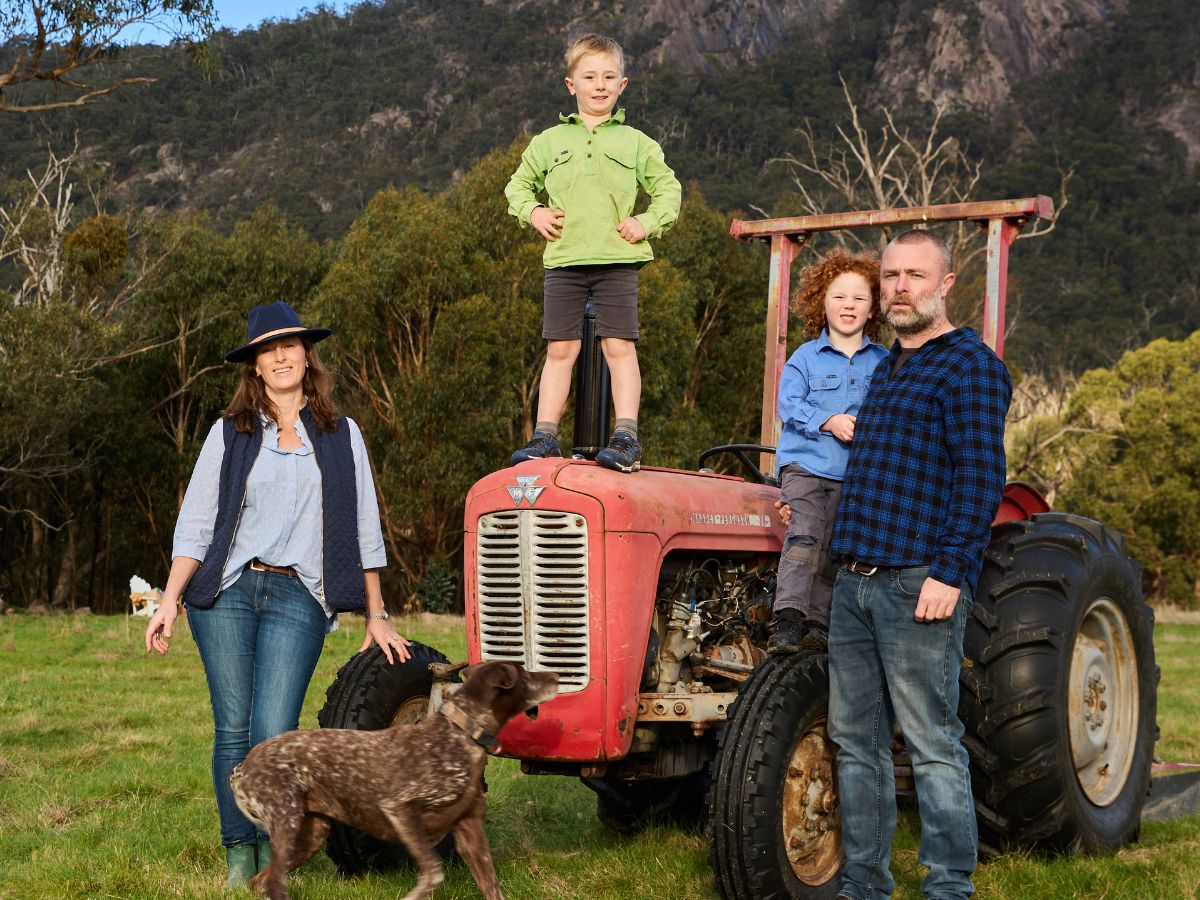 adam, nancy and their two boys on the subrosa vineyard in the grampians standing around a red tractor